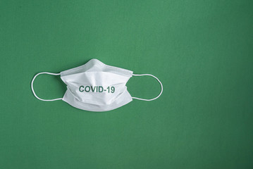 Surgical mask over minimalist green background