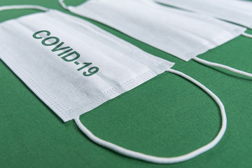 Surgical mask over minimalist green background