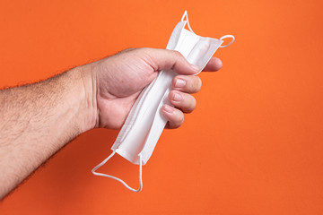 Man's hand holding surgical mask