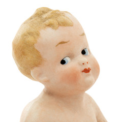 Face of vintage baby doll from ceramics closeup, isolated on white background