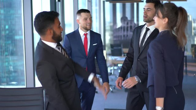 Multicultural corporate partners in formal wear enjoying synergy association during working day for brainstorming collaboration, successful men and woman celebrating approved business project
