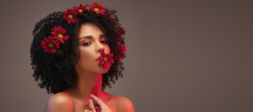 Beauty afro girl with flowers in hair.