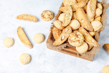 Various cookies in a wooden tray on gray background