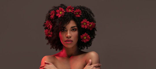 Beauty afro girl with flowers in hair.