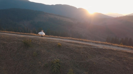 Obraz premium Newlyweds dancing on a high slope of the mountain. Groom and bride. Aerial view