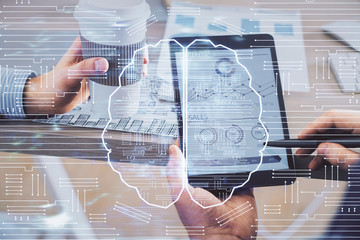 Double exposure of man's hand holding and using a digital device and brain hologram drawing. Data concept.