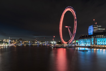Stunning London, United Kingdom city at night. London in summer time with wheel eye running around...