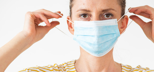  woman putting on a medical mask coronavirus protection