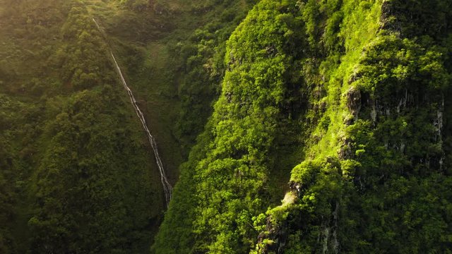 Haena State Park. Hawaii. Impressive aerial footage of green mountain slopes, densly covered with lush greenery. Bright tropical nature. The scene is lit with the sun. Aerial, 4K