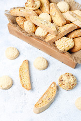 Various cookies in a wooden tray on gray background