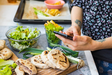 Smartphone food photography for lunch or dinner. Making lifestyle photo of stuffed bread cakes with phone. Concept for social media blogging and online order services. Vegan and vegetarian diet.
