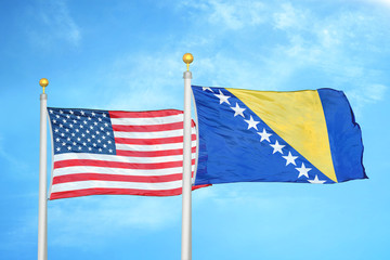 United States and Bosnia and Herzegovina  two flags on flagpoles and blue cloudy sky