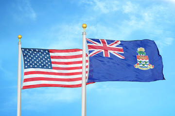 United States and Cayman Islands two flags on flagpoles and blue cloudy sky