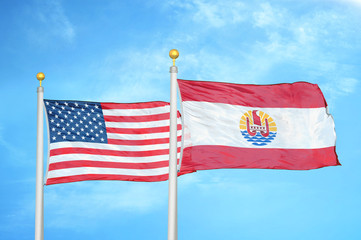 United States and French Polynesia two flags on flagpoles and blue cloudy sky