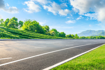 Asphalt road and green tea mountain nature landscape on sunny day,panoramic view.
