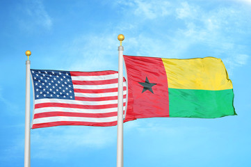 United States and Guinea-Bissau two flags on flagpoles and blue cloudy sky