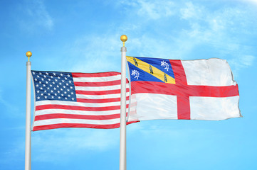 United States and Herm two flags on flagpoles and blue cloudy sky
