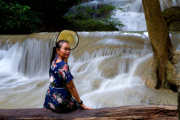 Traveler sit relax on timber at Erawan Waterfall and  natural