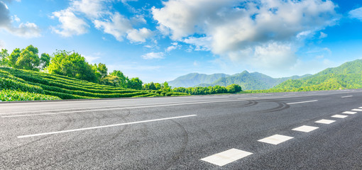 Asphalt road and green tea mountain nature landscape on sunny day,panoramic view.
