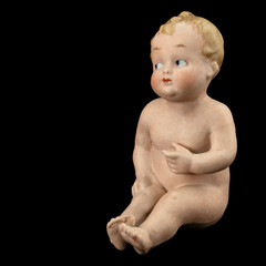 Vintage baby doll from ceramics, isolated on black background