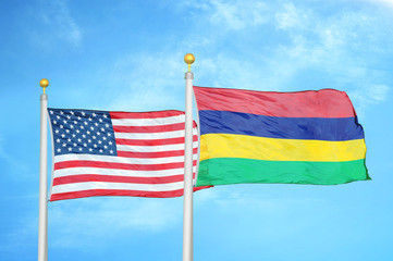United States and Mauritius two flags on flagpoles and blue cloudy sky