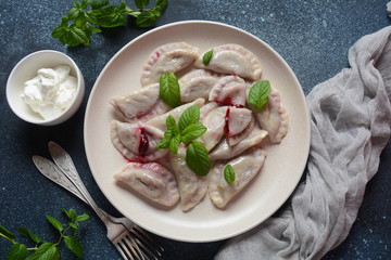Dumplings with cherries,sour cream and mint. Ukrainian, Russian and Belarusian cuisine. Healthy breakfast