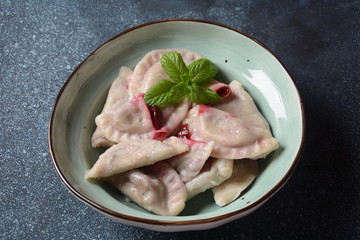 Dumplings with cherries,sour cream and mint. Ukrainian, Russian and Belarusian cuisine. Healthy breakfast