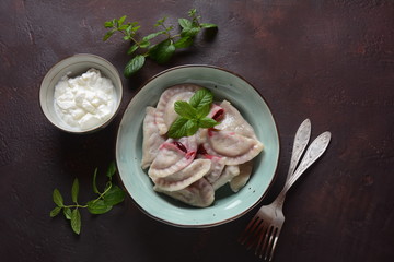 Dumplings with cherries,sour cream and mint. Ukrainian, Russian and Belarusian cuisine. Healthy breakfast