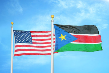 United States and South Sudan two flags on flagpoles and blue cloudy sky