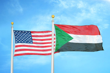 United States and Sudan two flags on flagpoles and blue cloudy sky