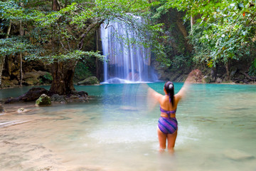 Woman with swimsuit enjoy in water at Erawan Waterfall