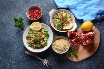 Healthy salad with couscous, fresh mint, cucumber, pomegranate, lemon and olive oil. Eastern cuisine. Vegan food concept. Traditional Israeli food
