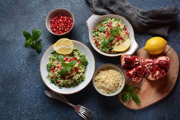 Healthy salad with couscous, fresh mint, cucumber, pomegranate, lemon and olive oil. Eastern cuisine. Vegan food concept. Traditional Israeli food