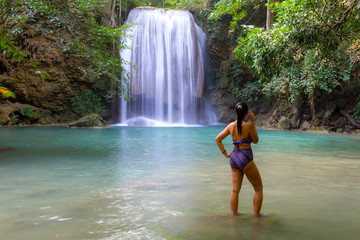 Woman with swimsuit happy in water at Erawan Waterfall and  natural