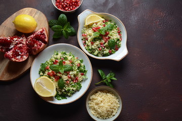 Healthy salad with couscous, fresh mint, cucumber, pomegranate, lemon and olive oil. Eastern cuisine. Vegan food concept. Traditional Israeli food