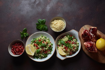 Healthy salad with couscous, fresh mint, cucumber, pomegranate, lemon and olive oil. Eastern cuisine. Vegan food concept. Traditional Israeli food