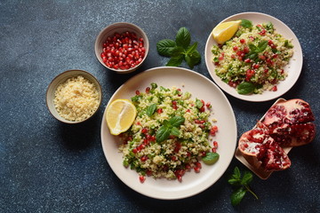 Healthy salad with couscous, fresh mint, cucumber, pomegranate, lemon and olive oil. Eastern cuisine. Vegan food concept. Traditional Israeli food