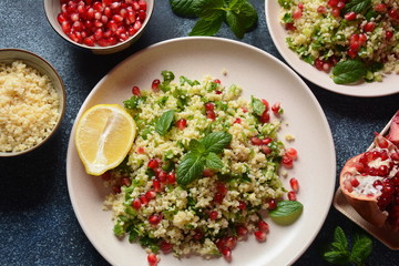 Healthy salad with couscous, fresh mint, cucumber, pomegranate, lemon and olive oil. Eastern cuisine. Vegan food concept. Traditional Israeli food