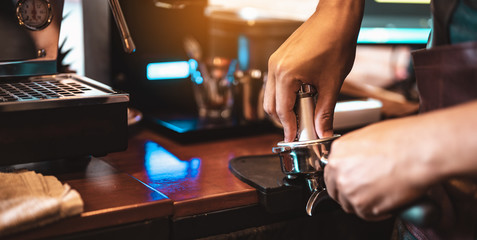 Close-up coffee maker that is professionally extracting coffee by barista with a deep white glass in the evening sun light. coffee, extraction, deep, machine, make, barista concept.