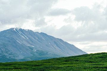 Fototapeta premium rocky ridge on horizon in mountain valley, green slopes of gentle hills, beauty of nature for relaxation and meditation