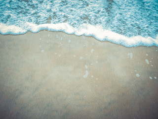  Waves with bluish foam on the beach sand