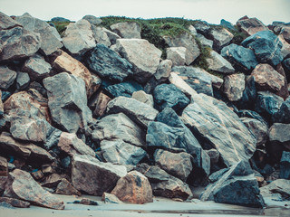  View of beautiful and colorful rocks on the beach under the clouds of the sky