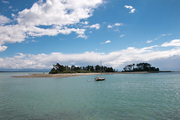 Beautiful tiny island in the tropical seawith a boat, calm summer seascape