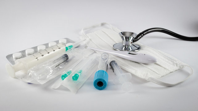 Diverse medical equipment isolated on white background.Surgical protection face mask, syringes, needles, test tube, digital thermometer,pills and stethoscope.Corona Covid-19 medical protection concept - Powered by Adobe