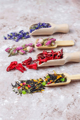 Assortment of dry tea in golden vintage mini plates.Tea types background:hibiscus,chamomile,mixed black tea,dry roses,butterfly pea tea