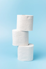 A stack of white toilet paper on blue background close up