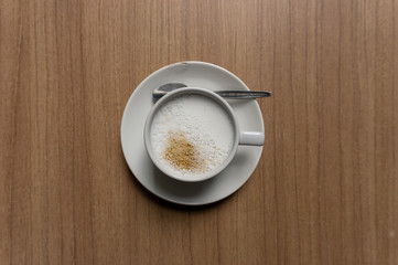 A white cup hot capuccino with white heart mug on brown wooden table top view image