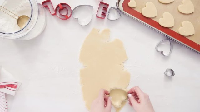 Flat lay. Step by step. Cutting out shapes from sugar cookie dough with cookie cutters.