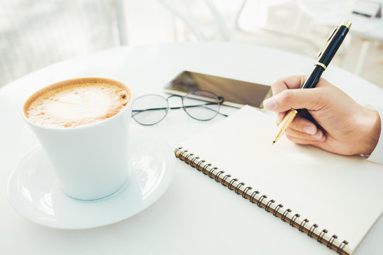 defocus hand of women writing with coffee in work from home concept