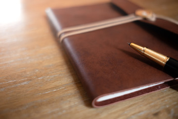 defocus pen and vintage diary on wooden table